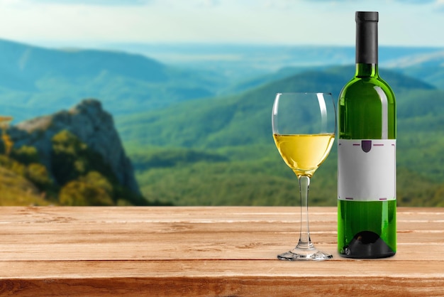 Bicchiere e bottiglia di vino bianco sullo sfondo della natura