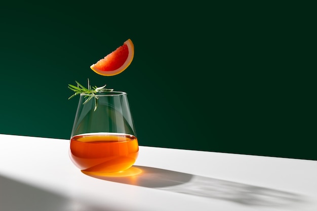 Bicchiere lucido di cocktail Negroni fresco con fetta d'arancia guarnita con rametto di rosmarino Copia spazio