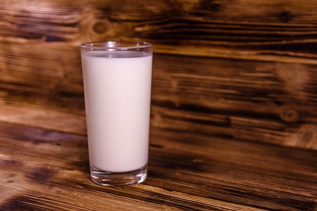 Bicchiere pieno di latte su un tavolo di legno