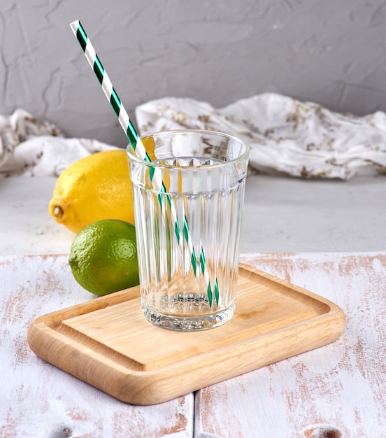 Bicchiere vuoto con sfaccettature e tubo da cocktail verde