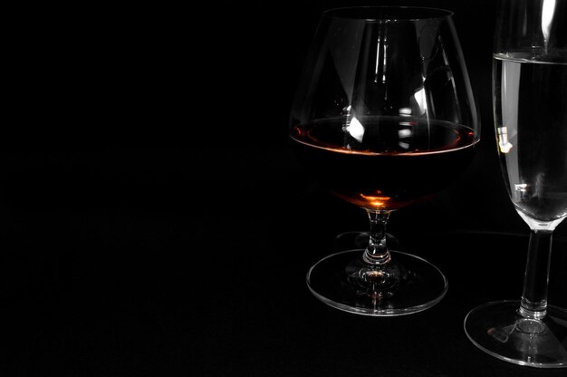 Bicchieri con bevande diverse Brandy whisky champagne o bourbon isolati su sfondo nero Foto di primo piano dell'alcol