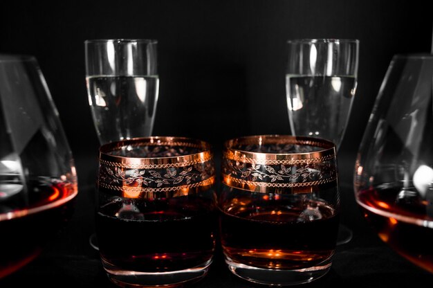 Bicchieri con bevande diverse Brandy whisky champagne o bourbon isolati su sfondo nero Foto di primo piano dell'alcol