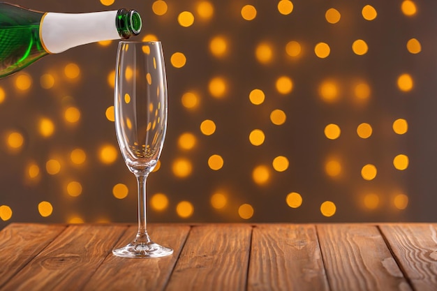 Bicchieri con champagne su uno sfondo di legno su uno sfondo bokeh di luci