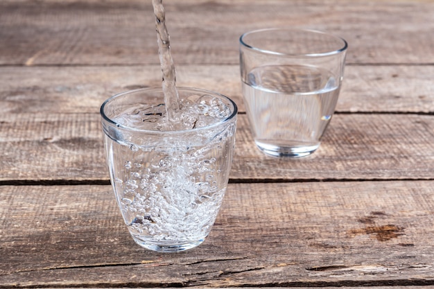 Bicchieri d'acqua su una tavola di legno.