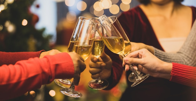 Bicchieri da bevanda momento tintinnante di allegre amiche sul maglione mentre divertiti a celebrare una relazione felice al delizioso evento della festa notturna di Natale. Aggiungi un po' di rumore per adattare l'immagine in stile vintage.