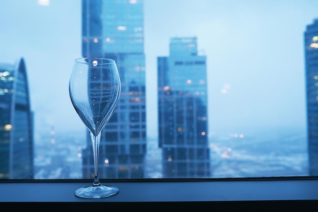 Bicchieri da cocktail sul davanzale della finestra vicino al vetro di un edificio alto