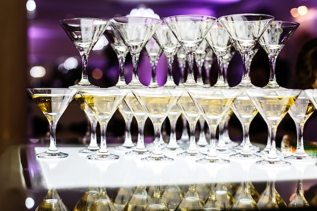 Bicchieri da Martini fanno piramide sul tavolo di vetro