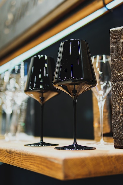 Bicchieri da vino neri vuoti sono sul tavolo del bar o del ristorante. Bicchieri alla moda