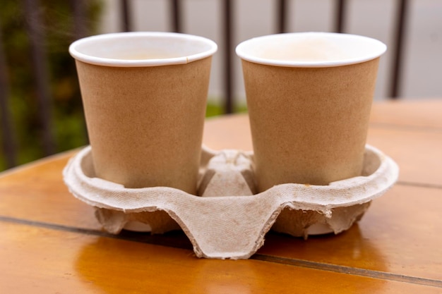 Bicchieri di carta con caffè sul tavolo di un caffè all'aperto Cibo da asporto