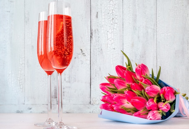 Bicchieri di champagne con bouquet di tulipani