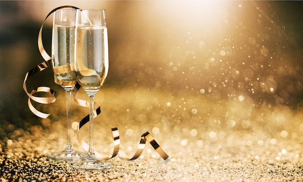 Bicchieri di champagne con nastro riccio su sfondo luminoso