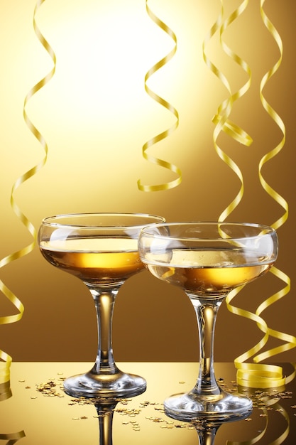 Bicchieri di champagne e stelle filanti su sfondo giallo