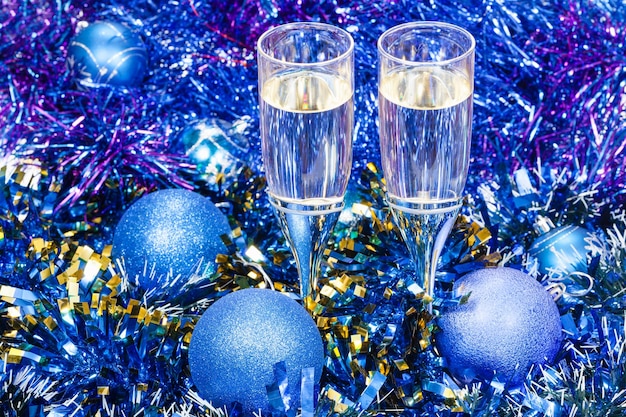 Bicchieri di champagne in palline di Natale blu e orpelli