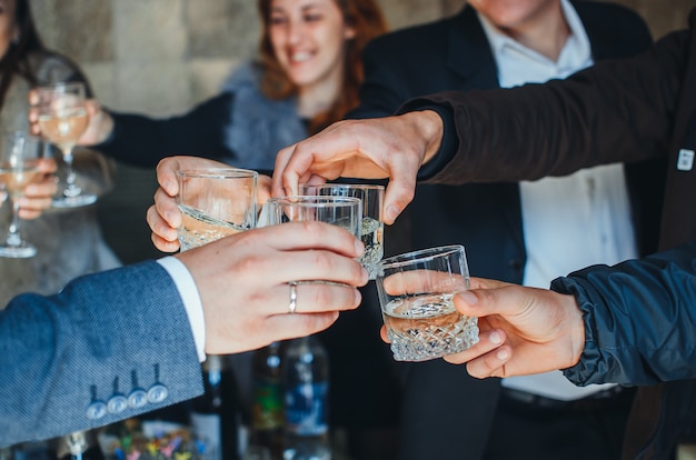 Bicchieri di champagne nelle mani di donne e uomini alla festa