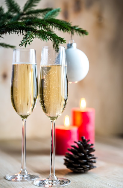 Bicchieri di champagne sotto il ramo di un albero di Natale decorato