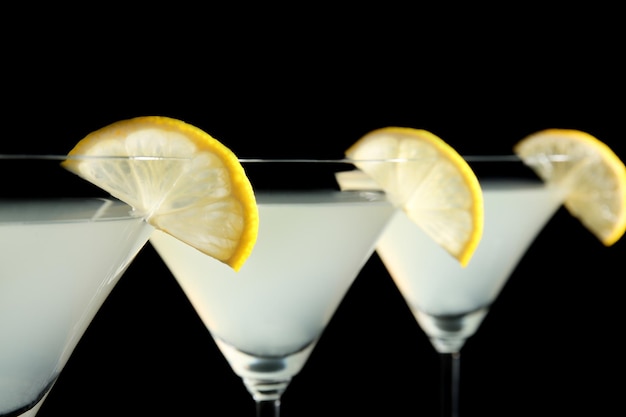 Bicchieri di martini al limone con fette di frutta su sfondo nero
