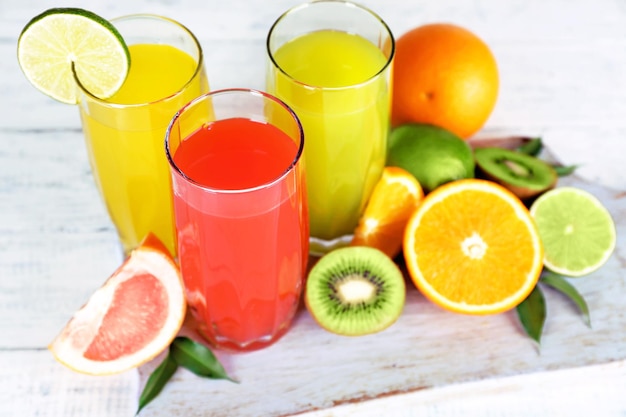 Bicchieri di succo diverso con frutta e menta sul tavolo da vicino