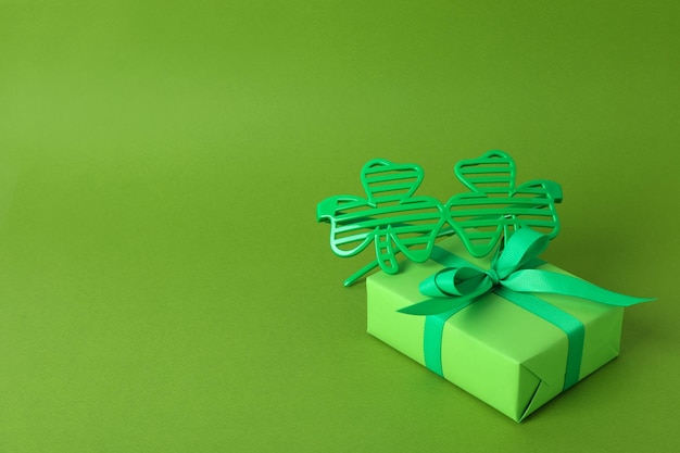 Bicchieri di trifoglio e confezione regalo su sfondo verde