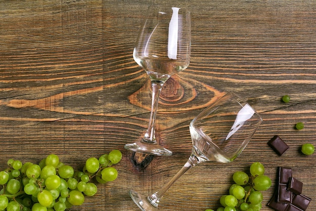 Bicchieri di vino e uva matura isolati su un tavolo di legno