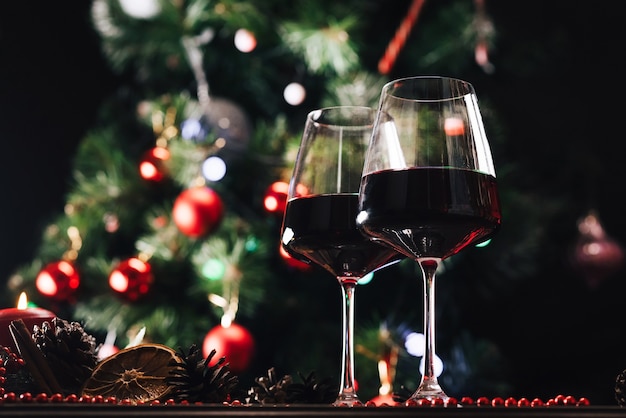 Bicchieri di vino sullo sfondo di un albero di Natale decorato. Capodanno