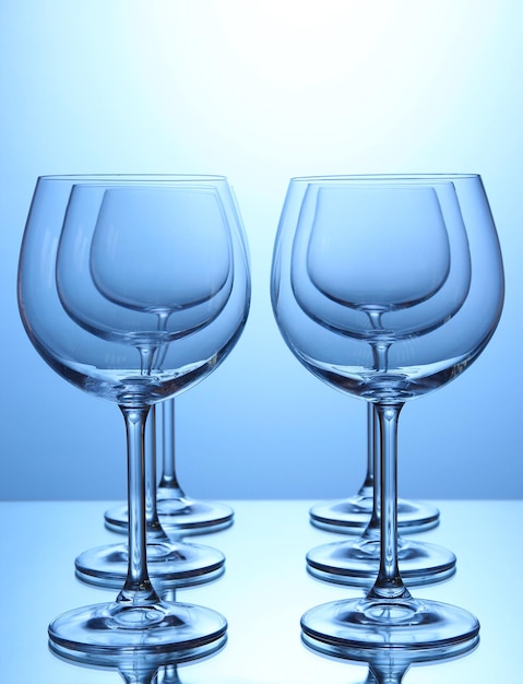 Bicchieri di vino vuoti disposti su sfondo blu