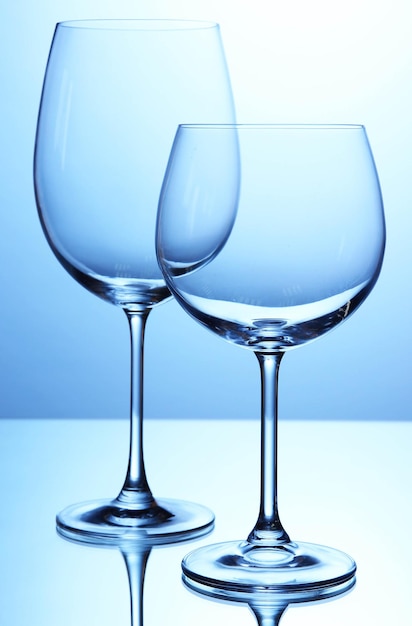 Bicchieri di vino vuoti disposti su sfondo blu