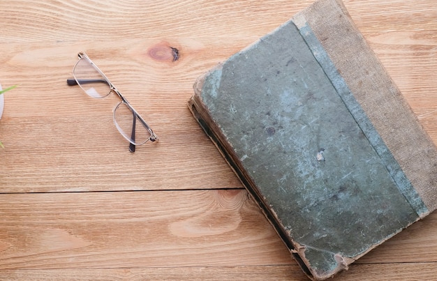 Bicchieri e un vecchio libro su un tavolo di legno