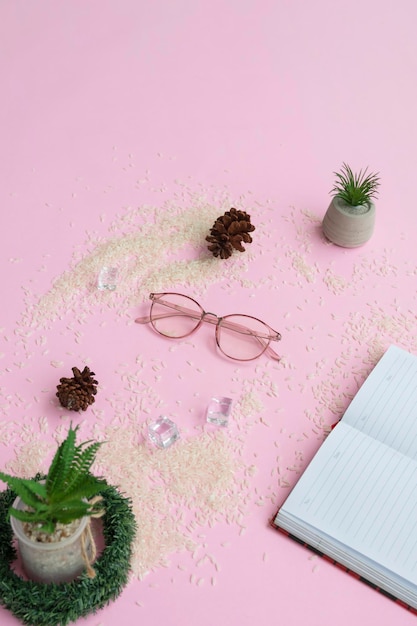 Bicchieri rotondi nella foto dall'alto con un concept minimalista su sfondo di carta viola con decorazioni a libro e piante di plastica