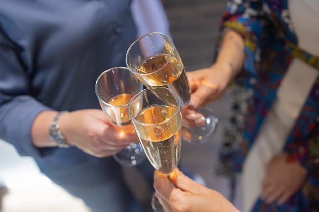 Bicchieri tintinnanti con alcol e brindisi, festa.