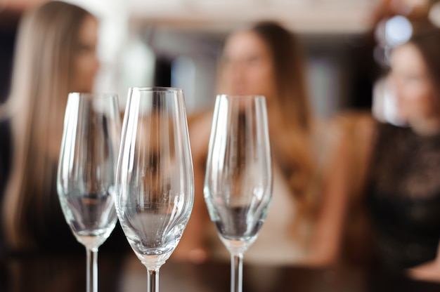 Bicchieri vuoti di champagne sullo sfondo delle ragazze