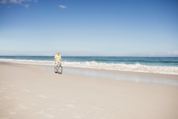 Bici di guida sorridente dell'uomo senior