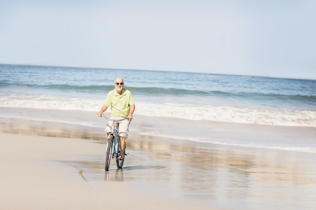 Bici di guida sorridente dell'uomo senior