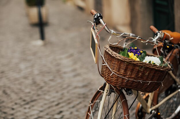 Bicicletta con cestino in vimini marrone e tavolino nero per scrivere.