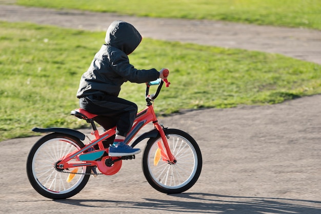 Bicicletta di guida del bambino. Ragazzo che impara ad andare in bicicletta.