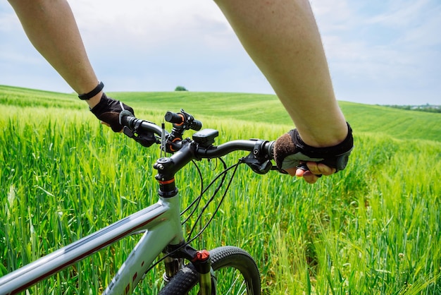 Bicicletta di guida del giovane uomo forte dal campo verde