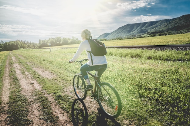 Bicicletta di guida della donna in campagna