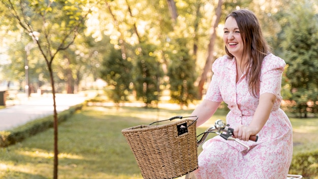 Bicicletta di guida della giovane donna elegante