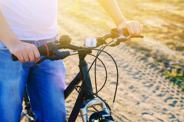 Bicicletta e uomo sulla natura da vicino, viaggio, stile di vita sano, passeggiata nel paese. telaio della bicicletta.