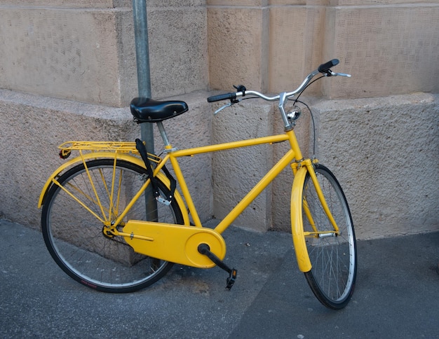 Bicicletta gialla legata al palo