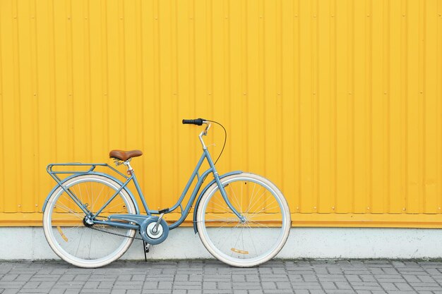 Bicicletta retrò vicino al muro giallo all'aperto