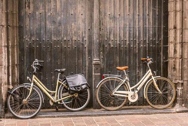 Biciclette appoggiate alla vecchia porta di legno all'ingresso della casa