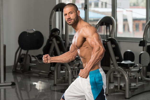 Bicipite Posa Di Un Giovane In Palestra