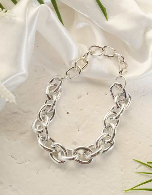 Bigiotteria alla moda - grande bracciale a catena in argento su un supporto bianco in primo piano