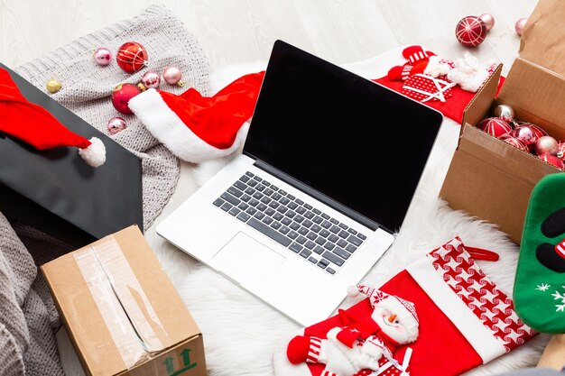 Biglietto di auguri di Natale, scatole regalo, laptop e tazza di caffè su fondo di legno. Vista dall'alto con copia spazio per il tuo testo