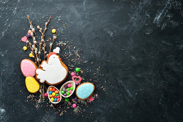 Biglietto di auguri di Pasqua Buona Pasqua Biscotti di pan di zenzero di Pasqua e uova colorate decorative su sfondo nero Vista dall'alto Spazio libero per la copia