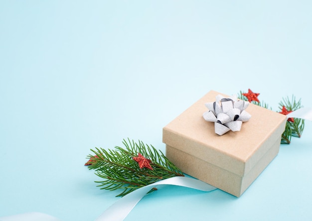 Biglietto di auguri per le vacanze di Natale con piccola confezione regalo, stelle, nastro e rami di abete