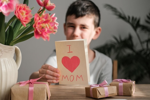 Biglietto fatto in casa per la mamma nelle mani di un ragazzo Buona festa della mamma