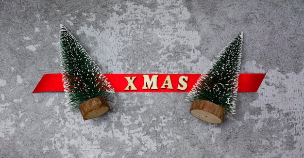 Biglietto natalizio. Due alberi di Natale con i saluti. Abete rosso con le parole natale.