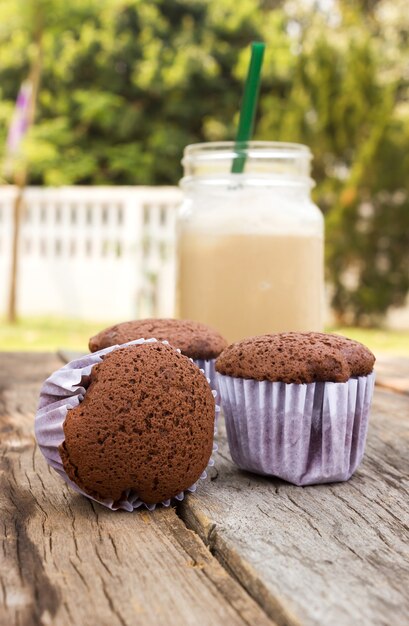 Bigné al cioccolato fatti in casa con caffè sul tavolo di legno.