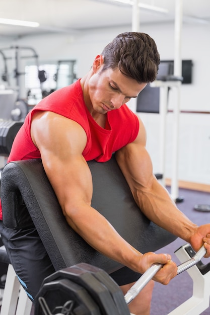 Bilanciere di sollevamento dell&#39;uomo muscolare in palestra